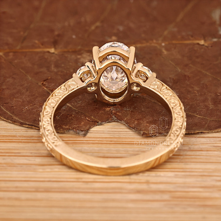 Basket setting diamond ring with oval centre and round sides.