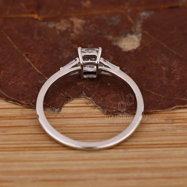 Four prong three diamond ring with radiant cut center and side diamonds.