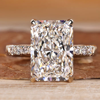 Radiant engagement ring with pave style with round stones.
