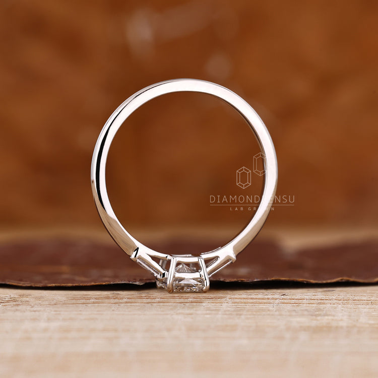 Handmade three diamond ring with cathedral setting and baguette side diamonds.