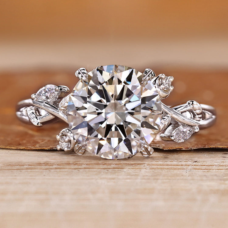 Nature inspired engagement ring with round center stone and marquise and round side stones.