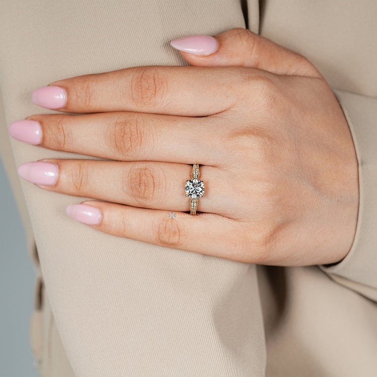 Round diamond ring with tapered shank and filigree.