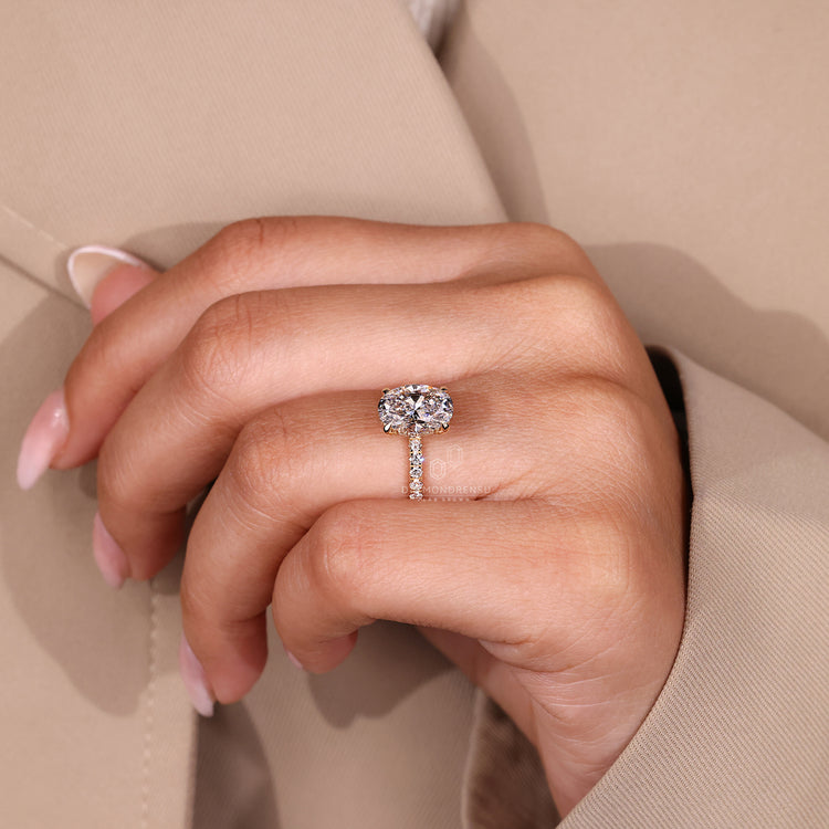 Oval cut diamond ring with four claw prong setting and hidden halo.