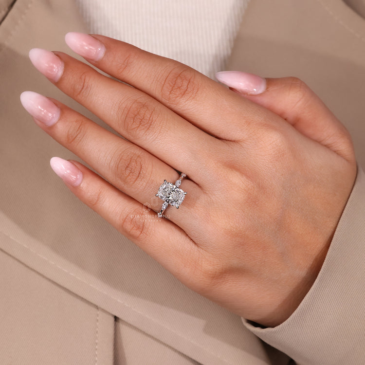Elongated cushion cut engagement ring with distance pave band and hidden halo.