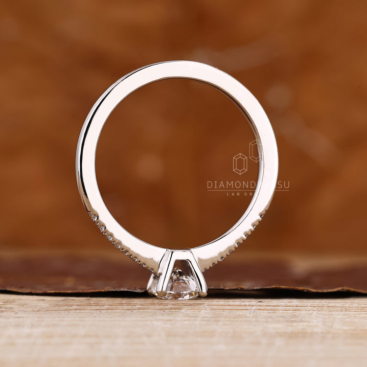 Handmade round diamond ring with pave setting and four prongs.