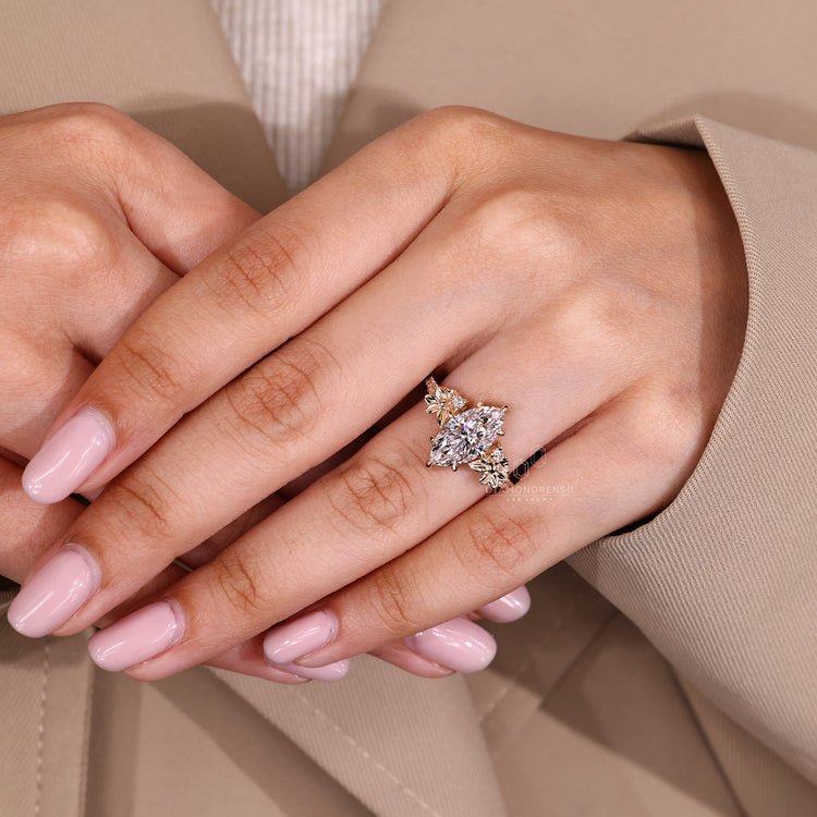 Marquise cut ring with round side stones and claw prong setting.