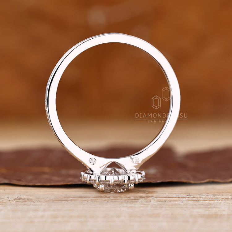 Handmade pear cut diamond ring with halo and round cut accents.
