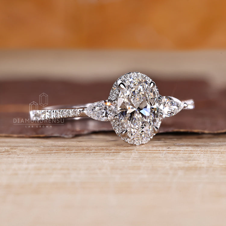 Oval diamond ring with pear sides and cathedral setting.