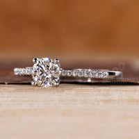 Round diamond ring with tapered shank and pave accents.