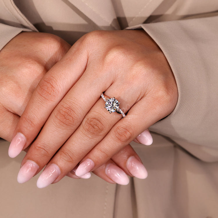 Six claw prong round diamond engagement ring with pave band.