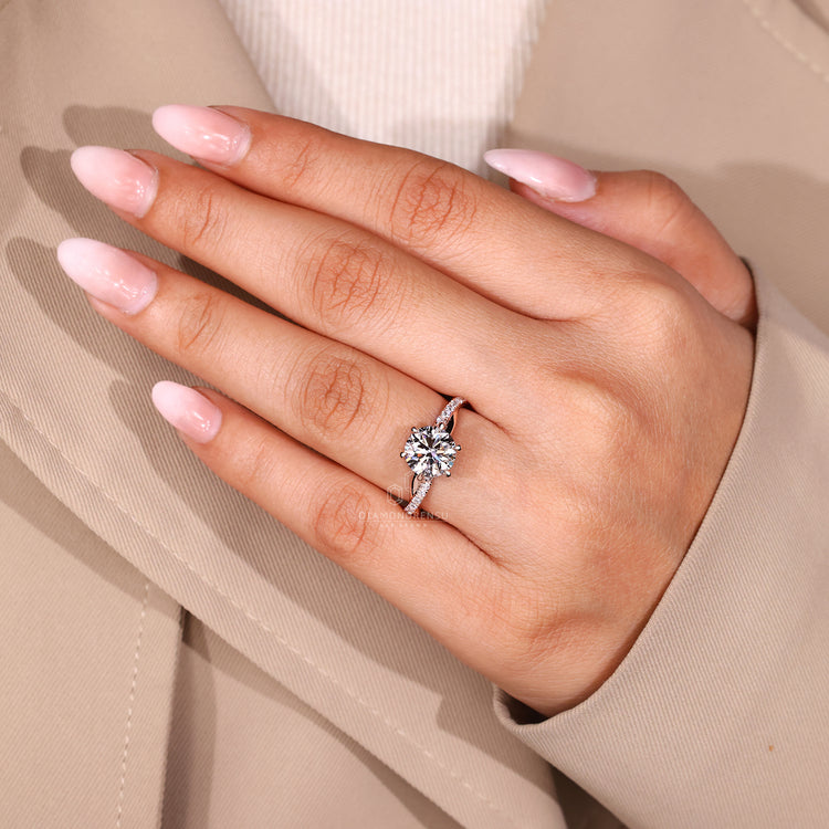 Round diamond engagement ring with twisted shank and round cut accents.