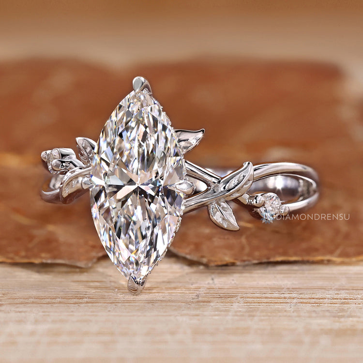 Marquise diamond ring with twisted shank and hidden halo design.
