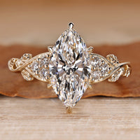 Marquise diamond ring with nature inspired style and round side stones.