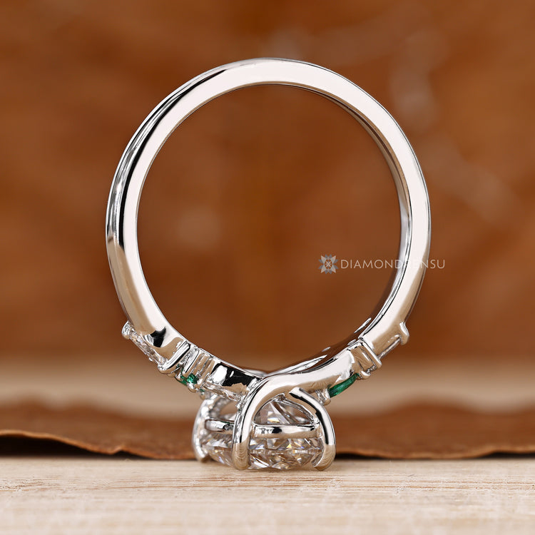 Oval engagement ring with a four prong setting and cluster design.