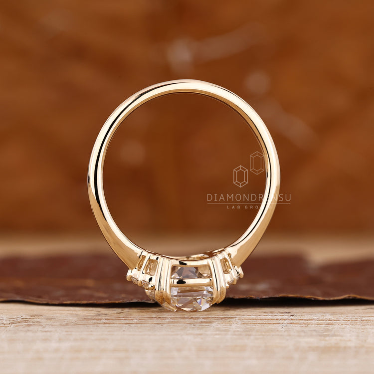 Lab grown cushion OMC diamond ring with classic side stone detail.
