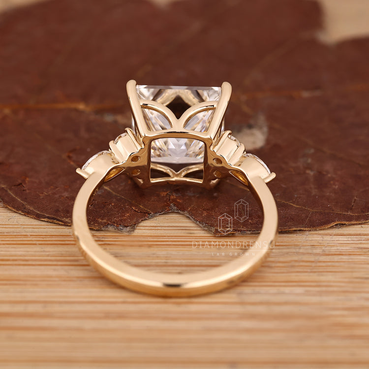 Princess cut diamond ring with tapered shank and side stones.
