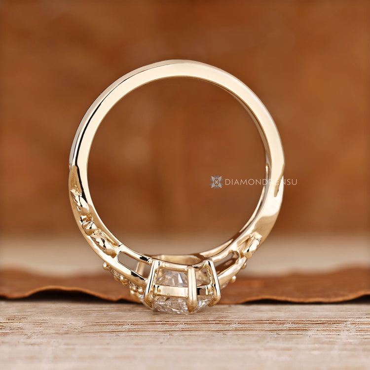 Handmade marquise ring with six claw prongs and round side stones.