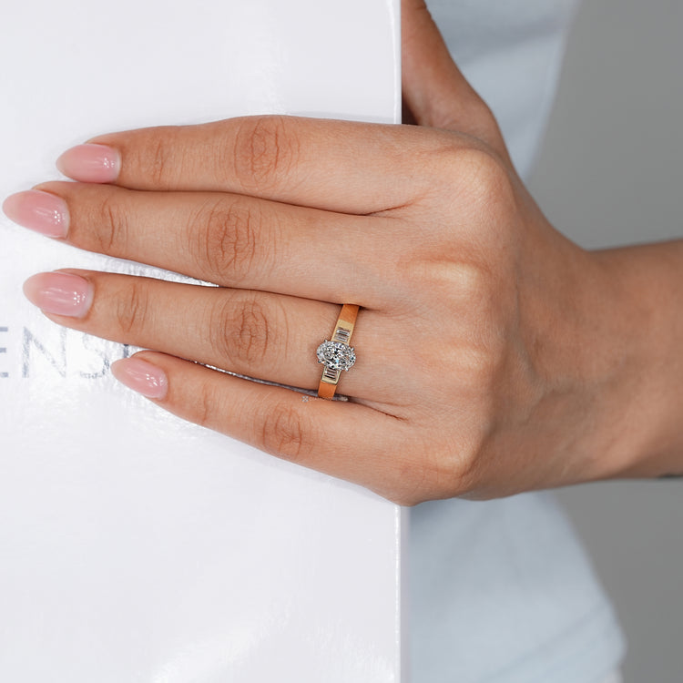 Two tone oval diamond ring with baguette side stones.