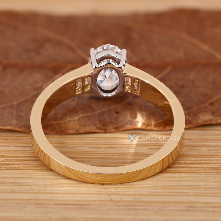 Oval diamond ring with baguette accents and four prongs.