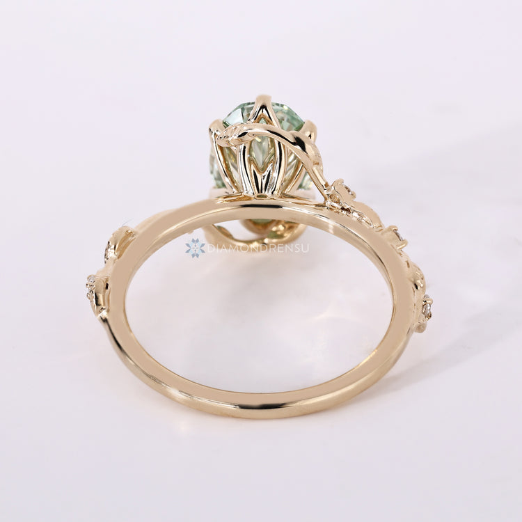 IGI certified green oval engagement ring with round side stones.