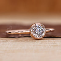 Lab grown round diamond ring in simple bezel style.