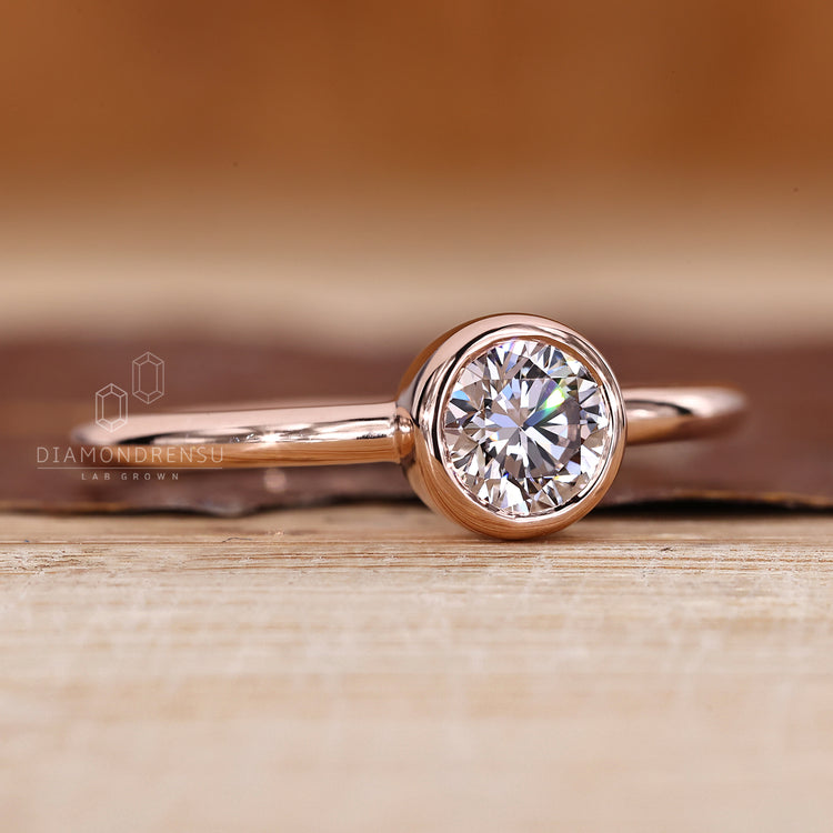Lab grown round diamond ring in simple bezel style.