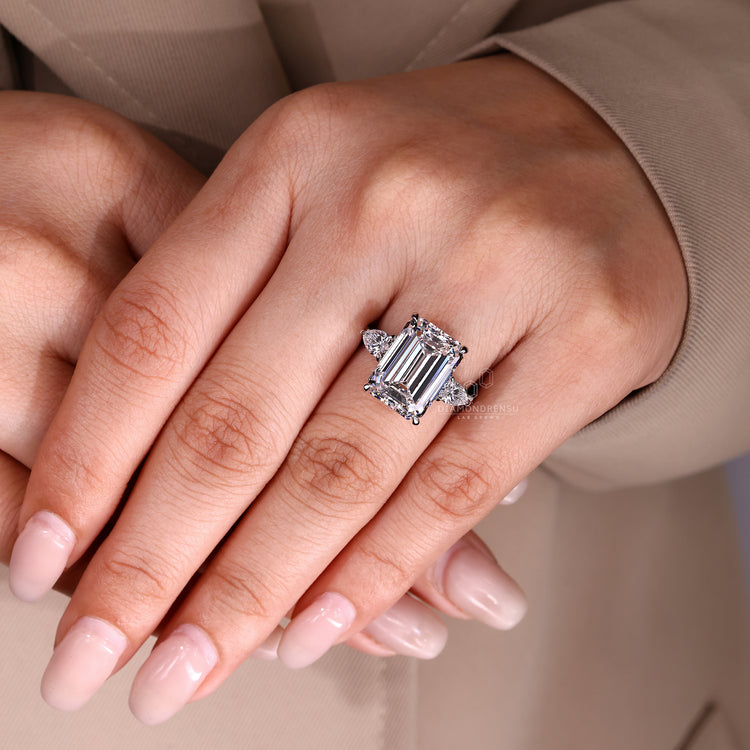 Emerald cut diamond ring with pear sides and tapered shank.
