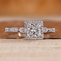 Halo diamond ring with princess center stone and pear side stones.