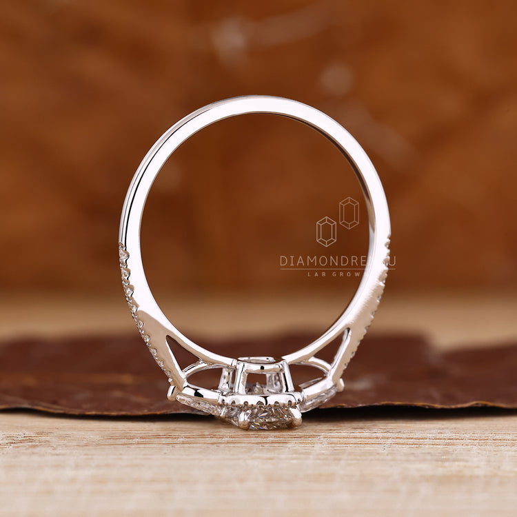 Oval lab diamond ring with pear sides and pave band.