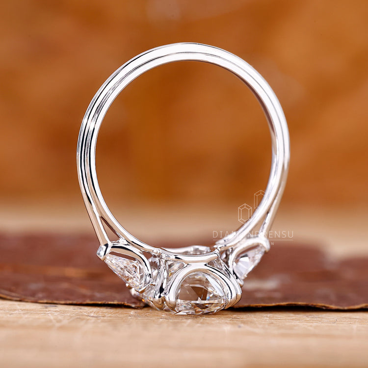 Three stone ring with cushion old mine center and pear accents.