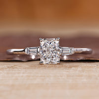 Three diamond ring with radiant cut center and tapered baguette side diamonds.
