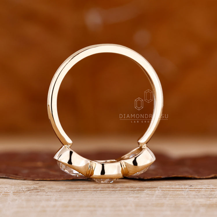 Elegant three stone diamond ring with bezel setting design.
