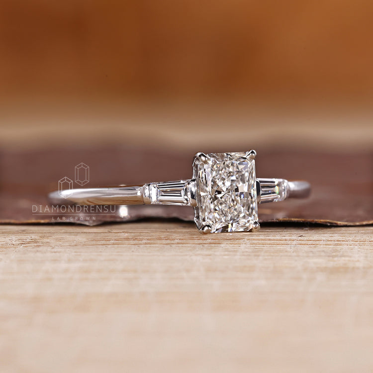 Three diamond engagement ring with radiant cut center and tapered side stones.