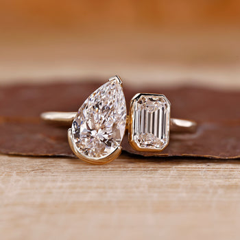 Toi et moi ring pear emerald diamonds cathedral setting.