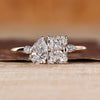 Two stone ring with pear and radiant cut diamonds and round side stones.