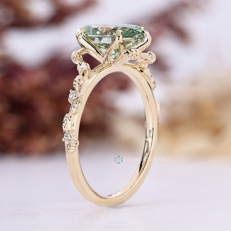 Nature inspired green oval engagement ring with round side stones.