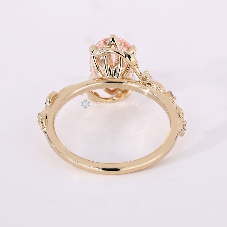 Nature inspired ring with pink oval center diamond.