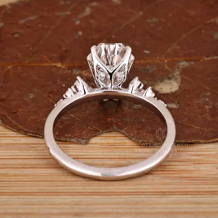 Handmade engagement ring with round side stones and prong setting.