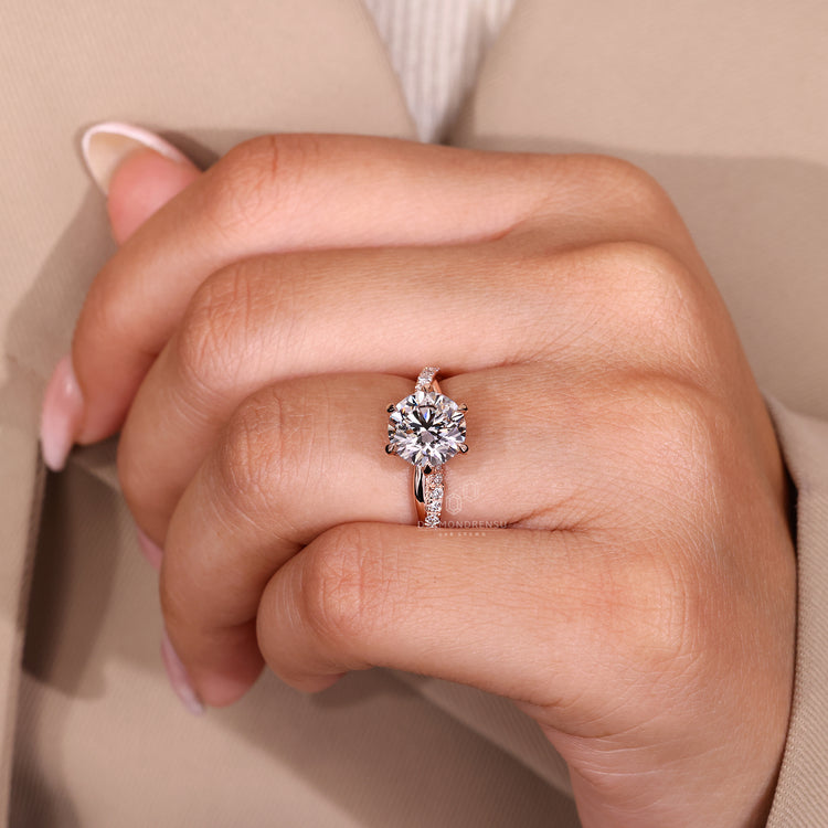 Round diamond engagement ring with six claw prong and twisted shank.