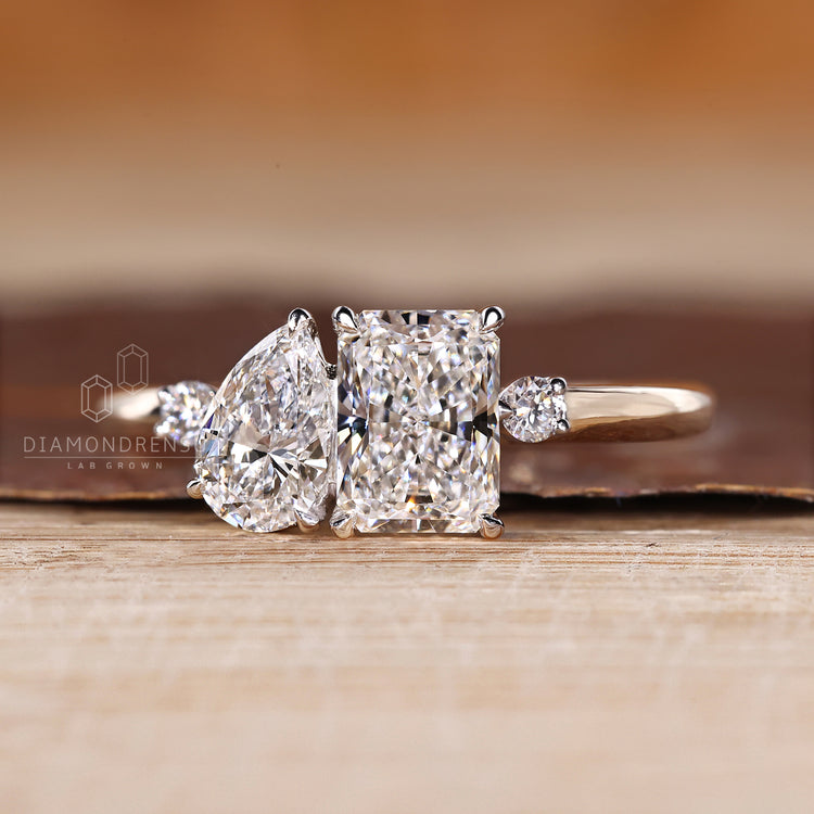 Two stone engagement ring with pear and radiant diamonds and round accents.