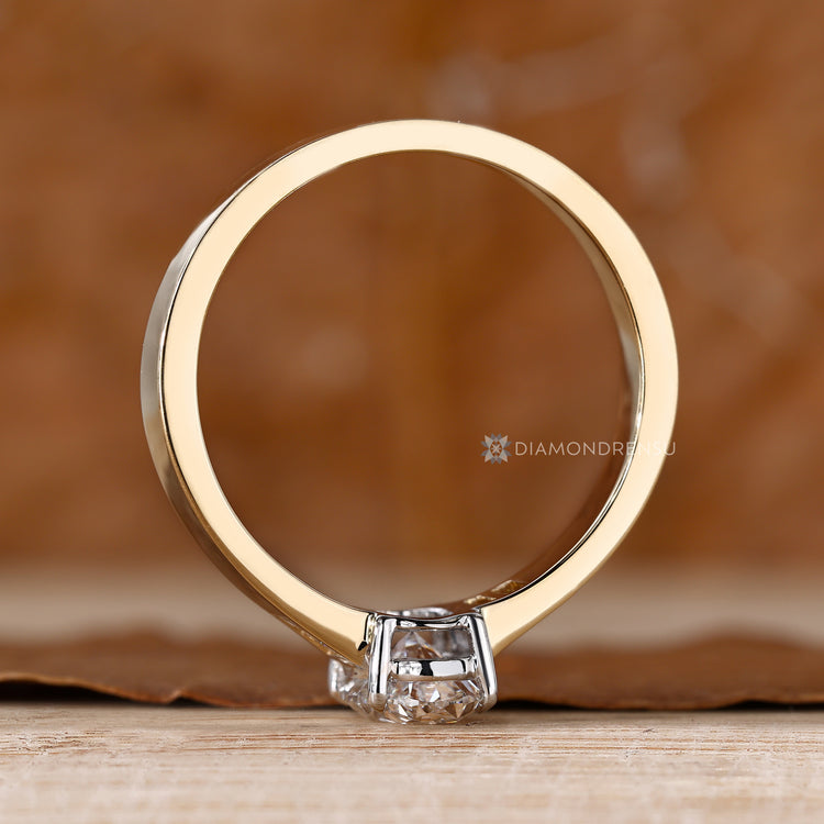 Oval cut lab grown diamond ring with four prongs.