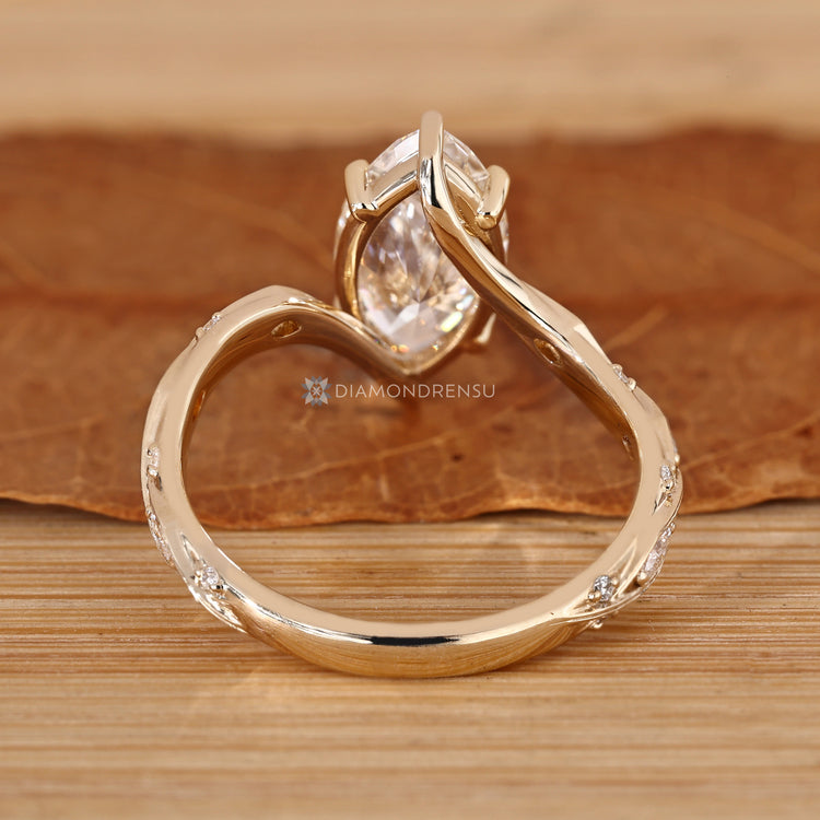 Marquise engagement ring with round side stones and a bypass setting.