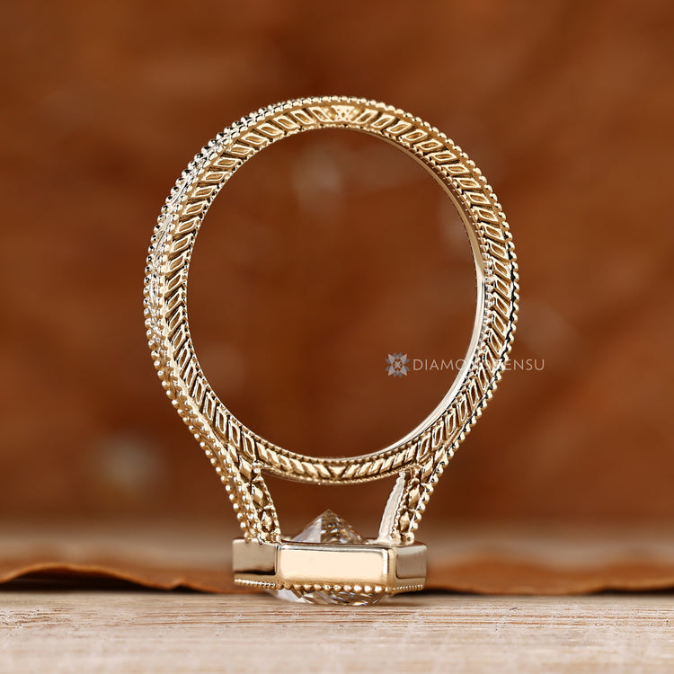 Dutch marquise center stone with milgrain details and bezel setting.
