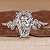 Cluster diamond ring with coffin center stone and round side stones.