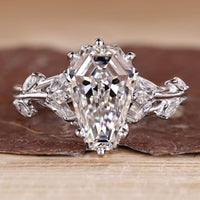 Nature inspired engagement ring with coffin center stone and marquise side stones.