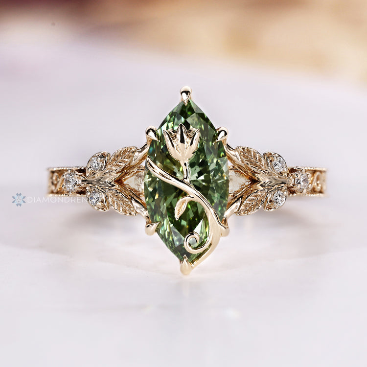 Marquise ring with a tulip flower motif over a green center stone.