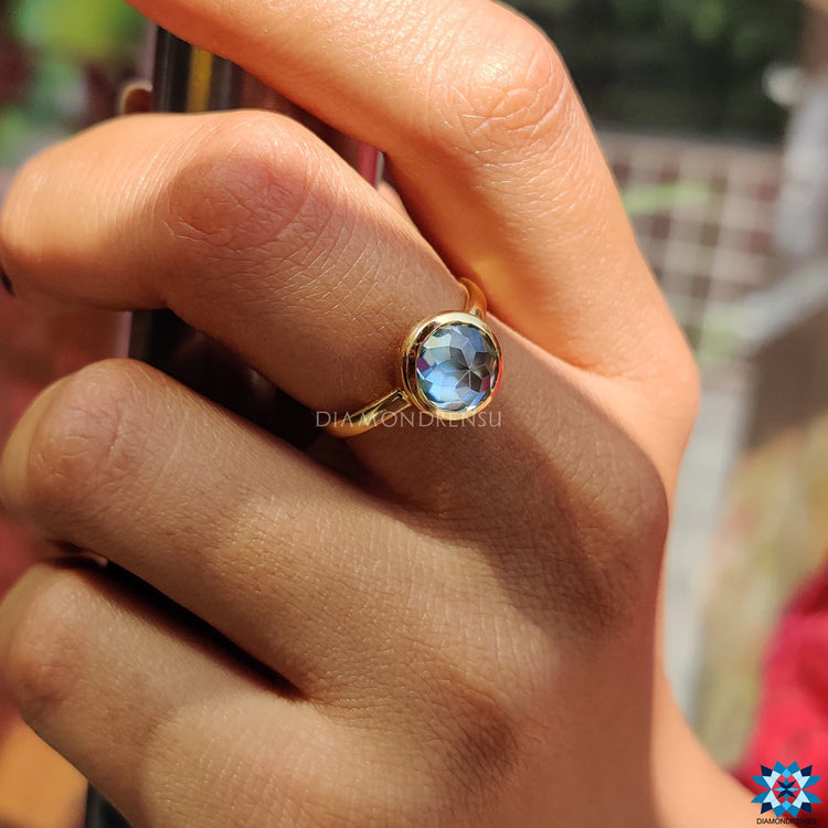 Blue-green moissanite ring with a vibrant sparkle.