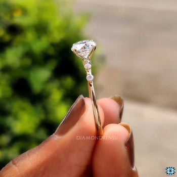 Round cut side stone engagement ring highlights beauty.
