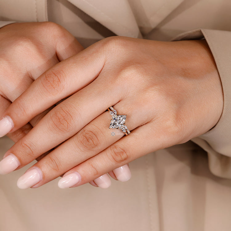 Six claw prong setting secures the marquise center stone.