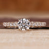 Round cut engagement ring with a pave setting crafted in yellow gold.
